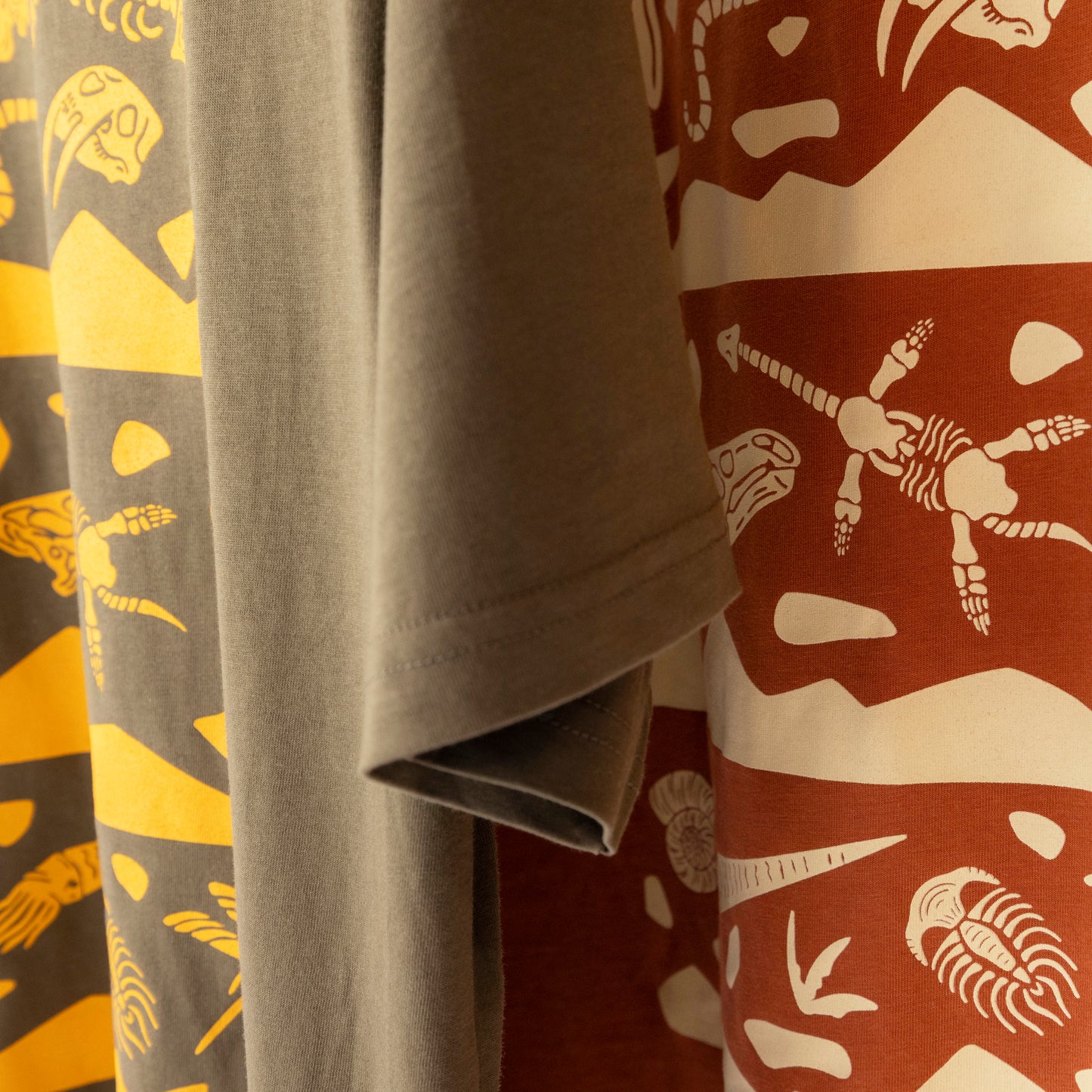 Green & rust fossil layer t-shirt side by side. Light-weight cotton soft prehistoric tee. 
Natural history t-shirts. dino shirts. dinosaur t-shirts

Paleozoic Era, Mesozoic Era, and Cenozoic Era 